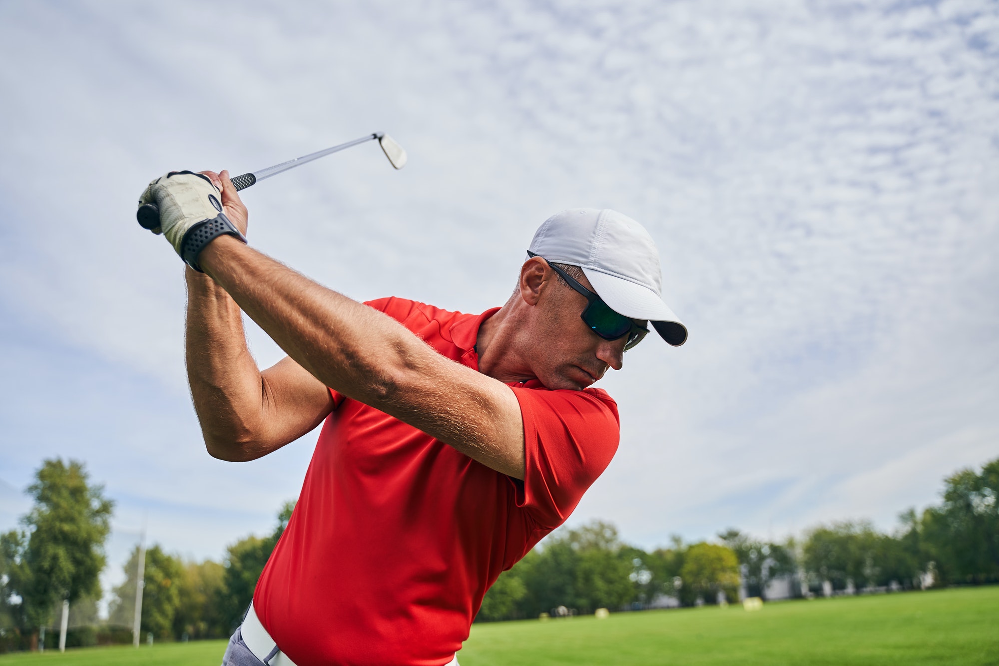 Male golfer doing a golf swing outdoors